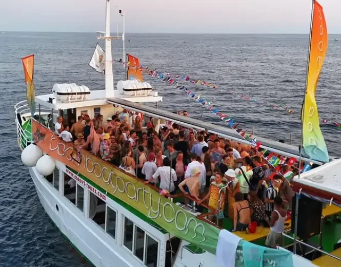 Crowd dancing at Boom Boat Party in Pula Croatia sailing on the Adriatic Sea with DJ and summer vibes